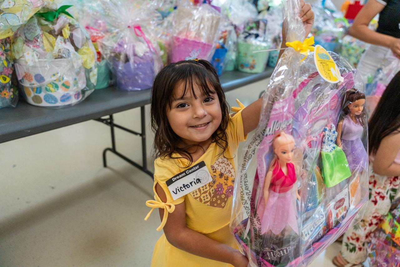 A young girl at SVdP's Easter Basket Distribution holds up the basket she chose.