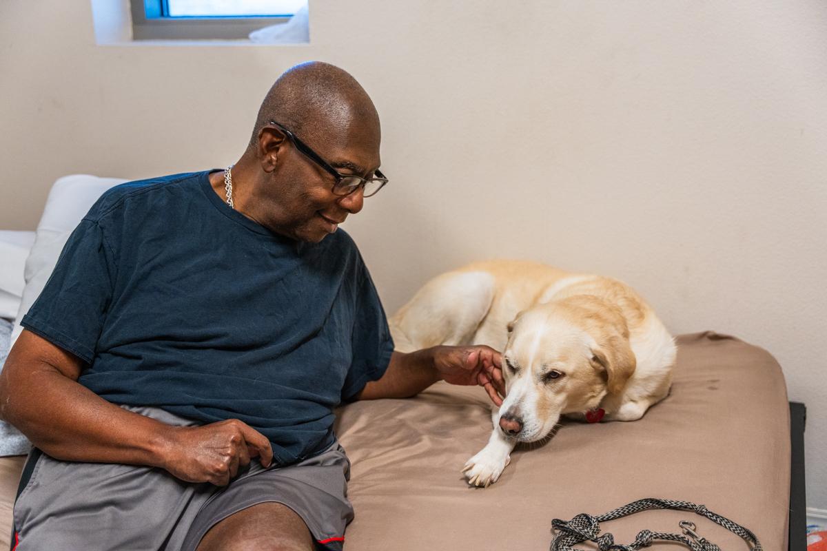 John pets Kimba in their Ozanam Manor dorm.