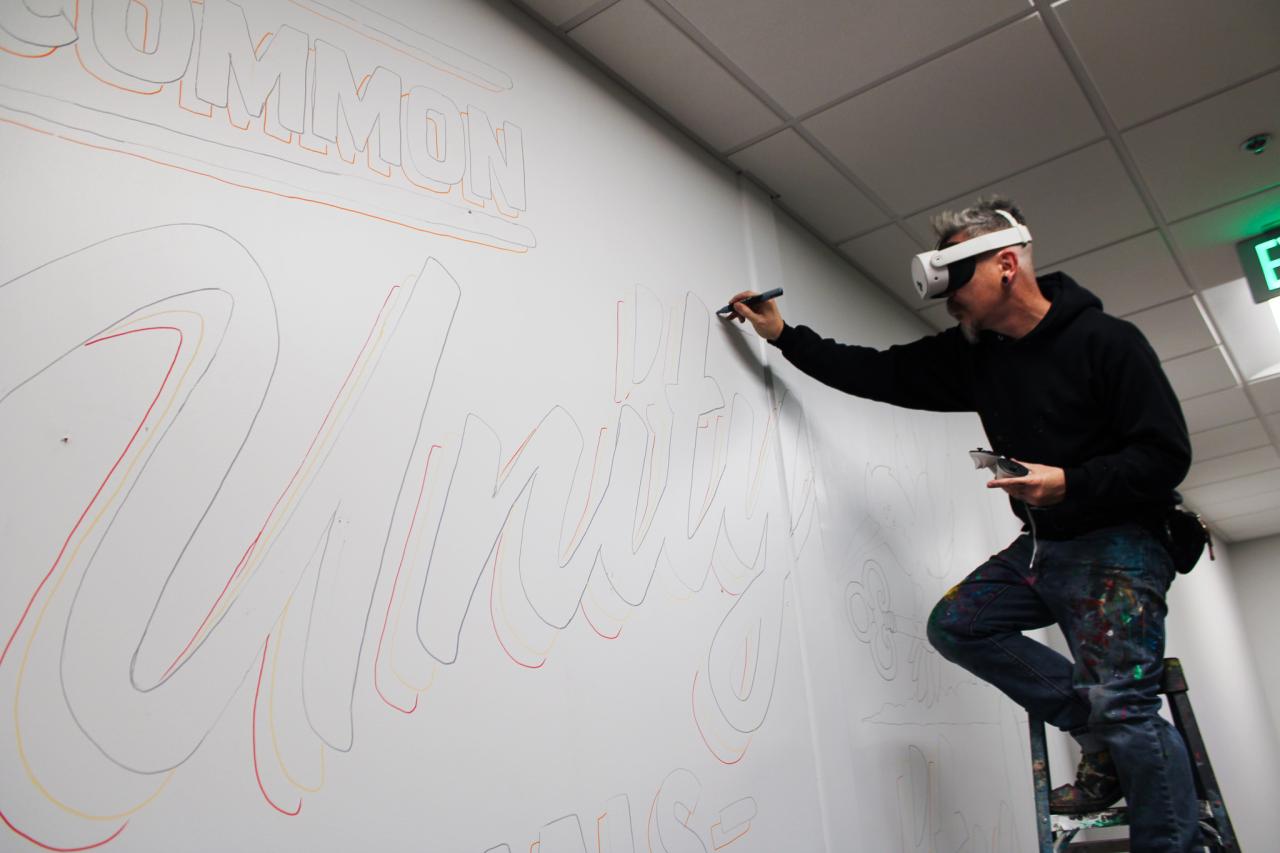 Jesse starts outlining the mural.