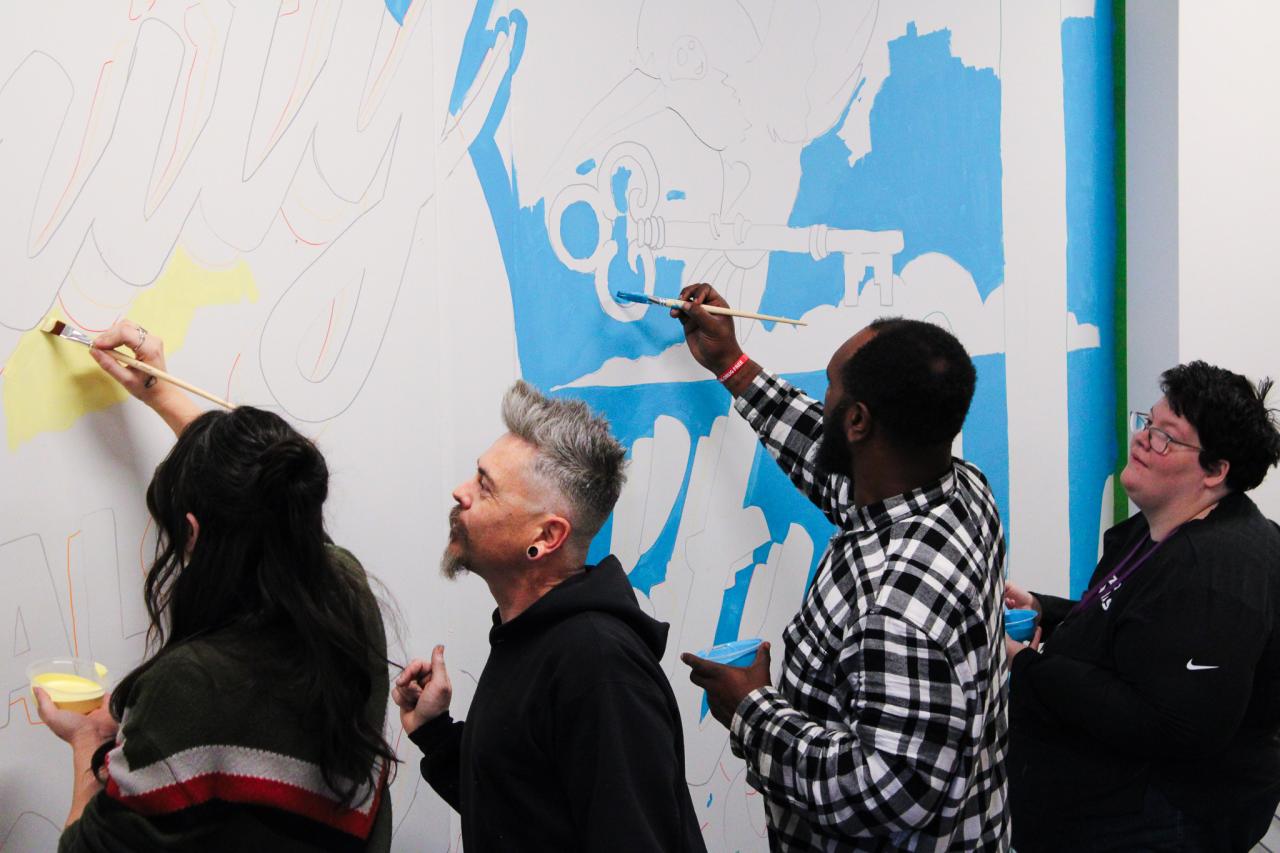 Jesse leads a group to paint the mural.