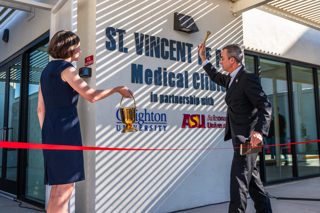 Creighton University President Rev. Daniel S. Hendrickson blesses the entrance of the medical clinic with SVdP CEO Shannon Clancy.